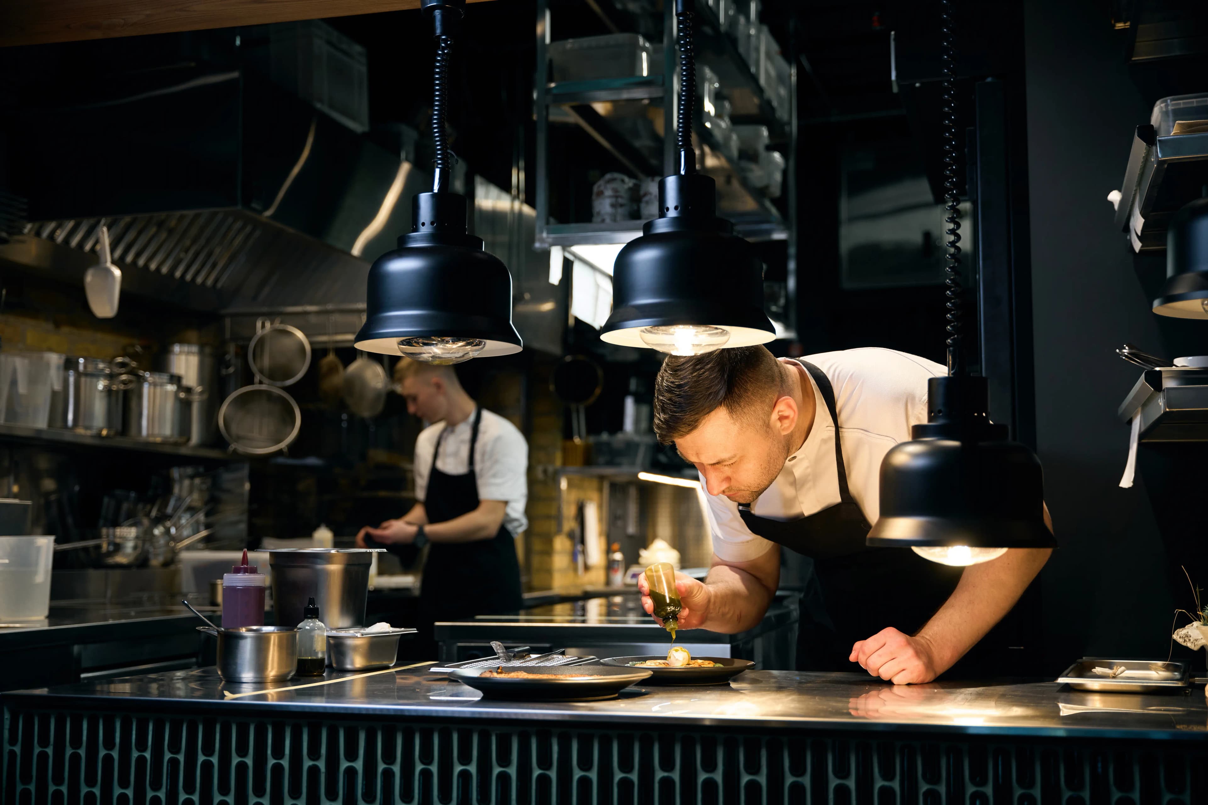 Chefs plating at a restaurant pass